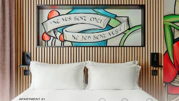 Une chambre à coucher comprenant un lit, deux lampes de chevet, une œuvre d’art accrochée au mur et un mur décoré de lattes de bois.