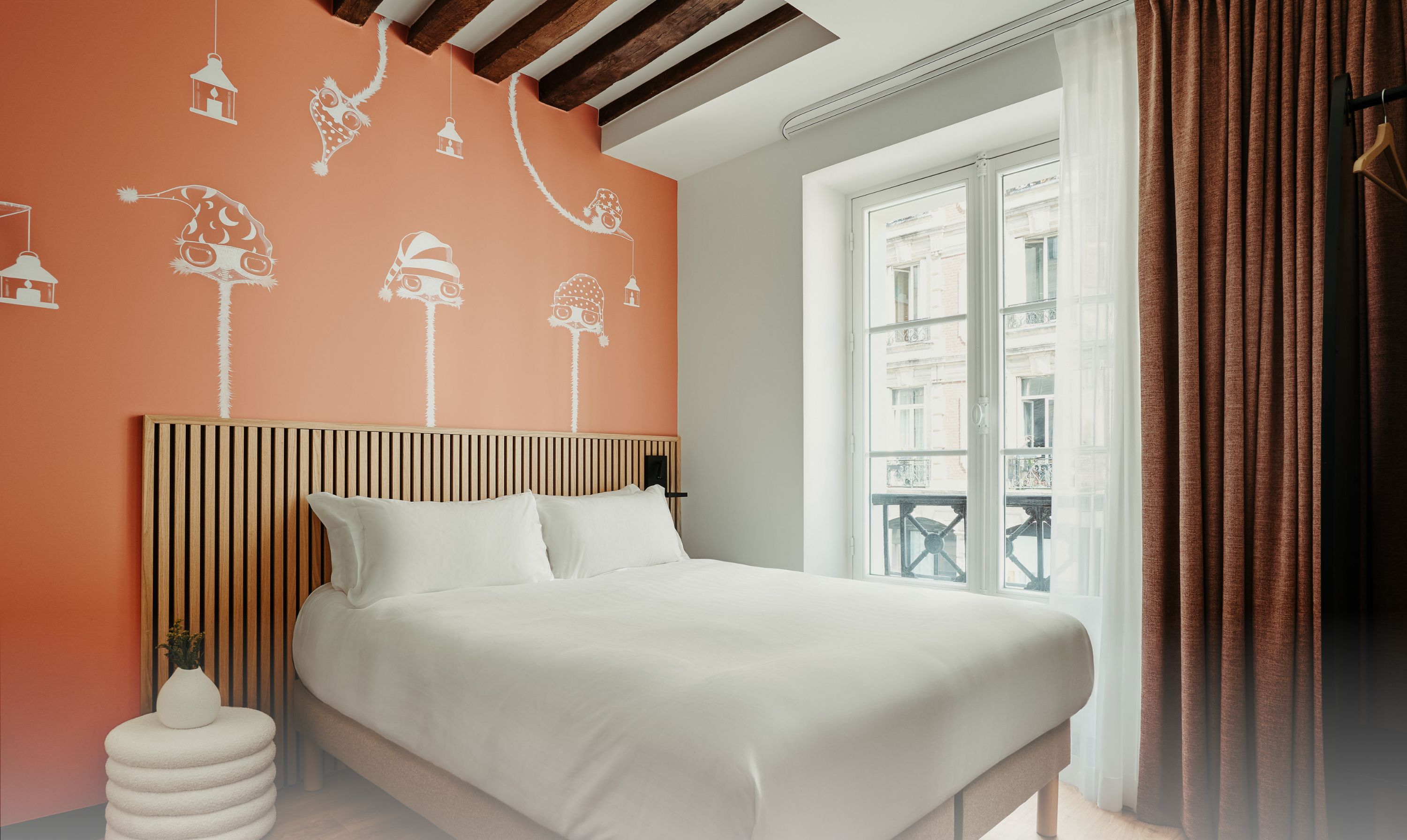A bedroom with a bed, a window with curtains, and a wall with decorative elements.