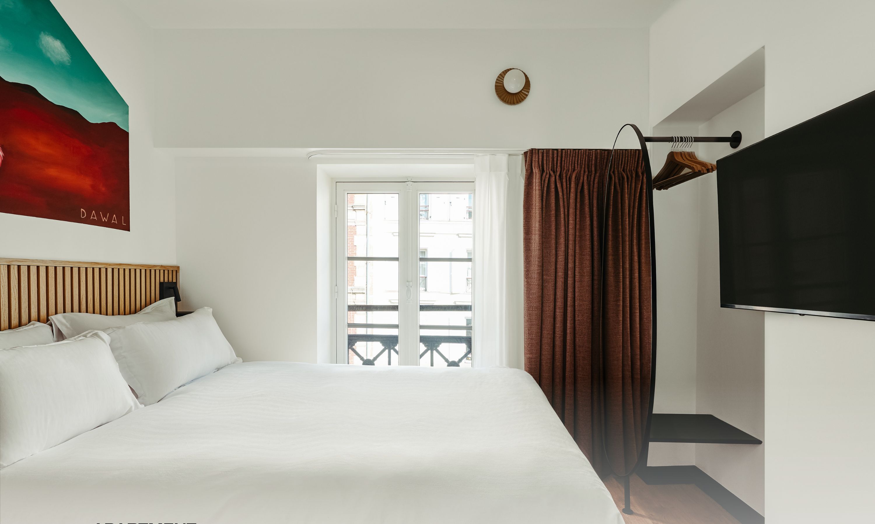 Une chambre à coucher avec un lit, une fenêtre, un téléviseur et une vue sur l’extérieur.