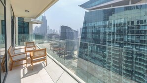 Een balkon met uitzicht op een modern glazen gebouw en stadsbeeld.