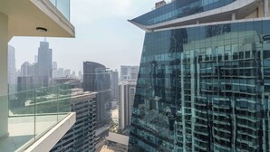 Een hoog gebouw met een glazen gevel die de stadsgezicht weerspiegelt.