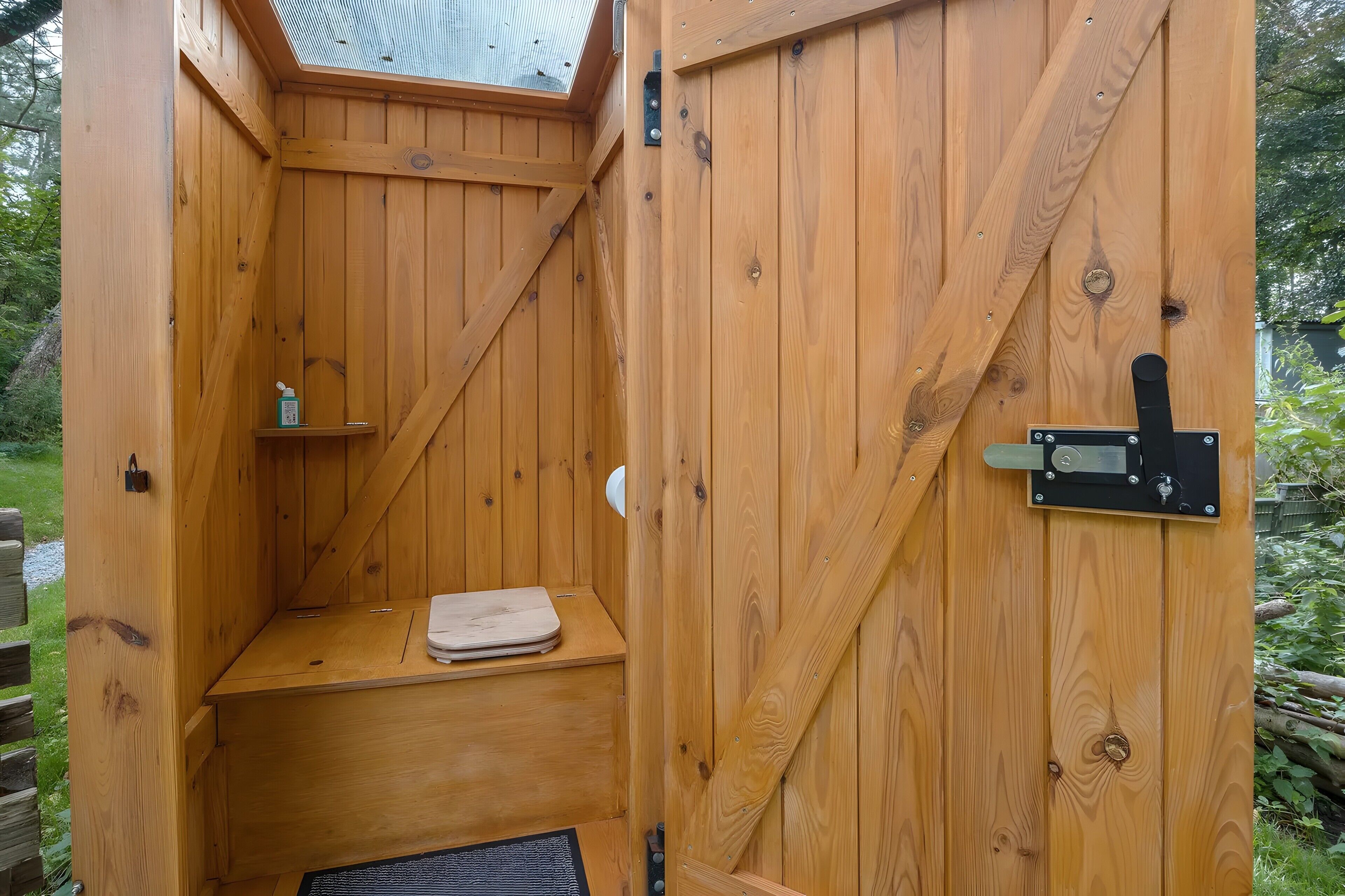 A wooden sauna with a bench, a shelf, and a door latch.