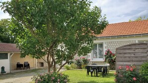 A house with a stone facade, a tiled roof, and a garden with a table and chairs. - La petite Chamarande, peaceful cottage with river view, close to Tours & Amboise (Montlouis-sur-Loire)
