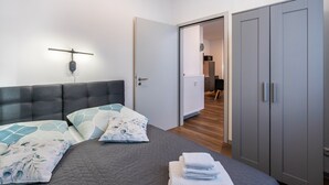 Une chambre à coucher comprenant un lit, une armoire et une porte donnant sur une salle de bain.