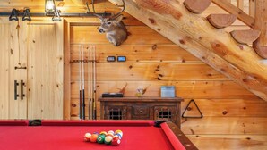 A pool table with balls, a deer head mounted on the wall, and wooden paneling. - Buffalo Lodge – Stay for 6 (Branson)