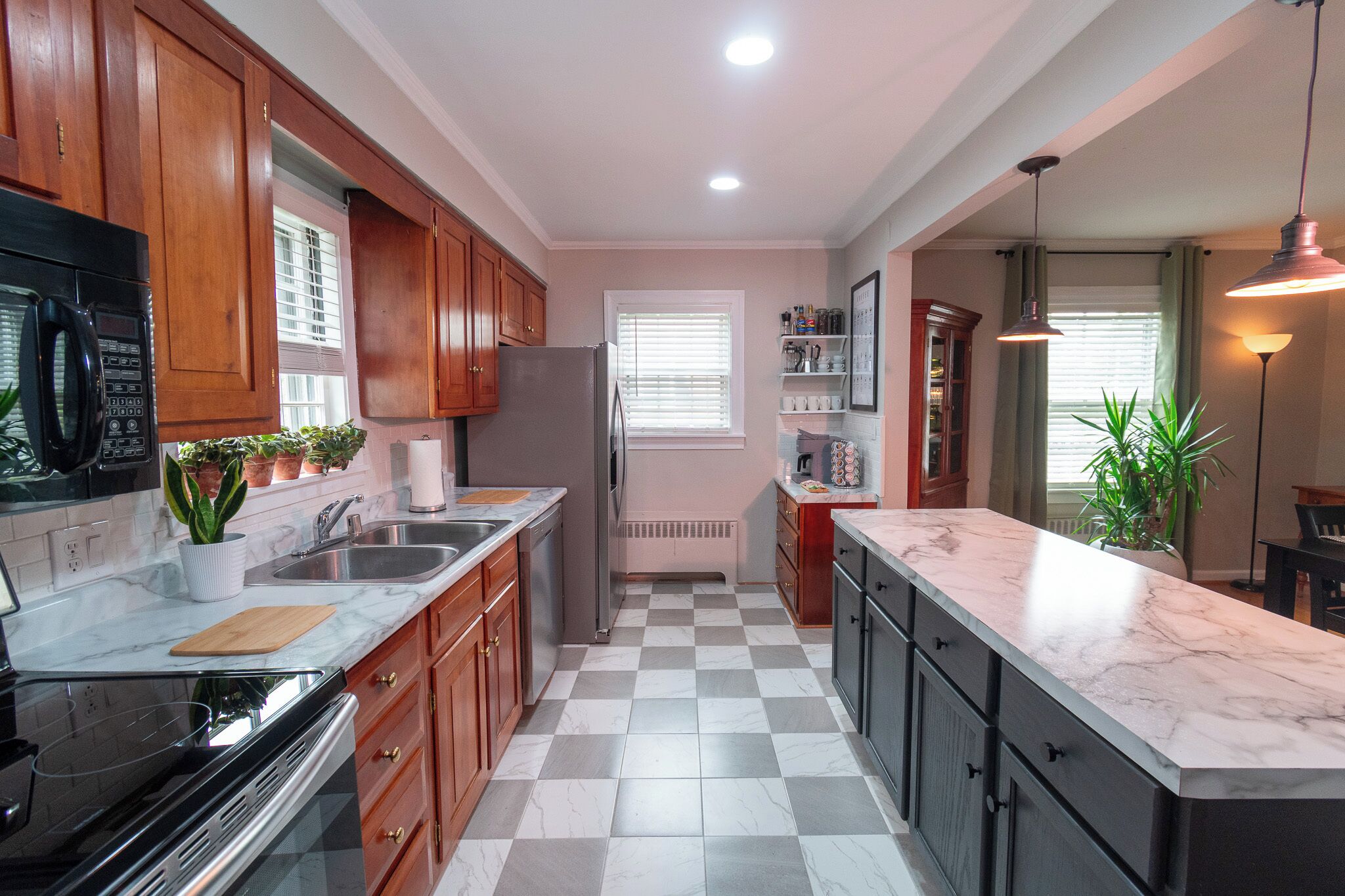 A kitchen with wooden cabinets, a marble countertop, a refrigerator, and a checkered floor.