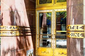 A theater entrance with a yellow door and columns. - Charming downtown 2-bedroom walkable condo with WiFi, free parking & gym. (Louisville)