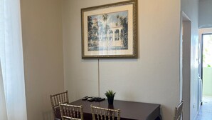 A dining area with a table and four chairs, a ceiling fan, and a framed picture on the wall. - 30 Day Minimum-3BR in Santurce-Near Beach UNIT 1 (San Juan)