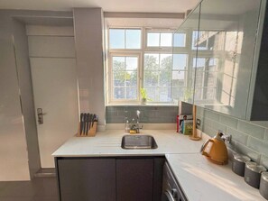 Een moderne keuken met een ingebouwd spoelreservoir, een raam met uitzicht en een koffieapparaat.