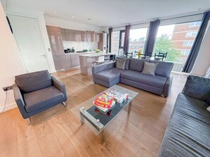 A modern living room with a sofa, armchairs, and a coffee table.