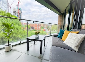 A balcony with a sofa, a table, and a potted plant. - 3bdr + Balcony | London bridge, borough, the shard (London)