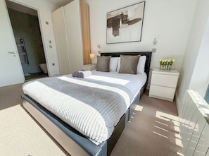 A bedroom with a bed, bedside tables, a nightstand, a wall-mounted lamp, and a framed abstract painting. - 3bdr + Balcony | London bridge, borough, the shard (London)