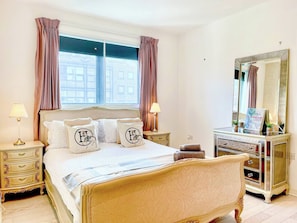 A bedroom with a large bed, bedside tables, a dresser, a mirror, and a window with curtains. - 3bdr Penthouse W/ Balcony | islington, kings cross (London)