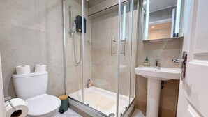 Une salle de bain moderne avec une douche à parois de verre, des toilettes et un lavabo.
