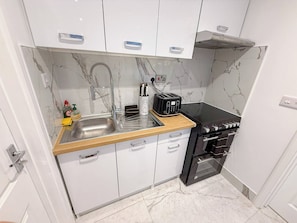 A compact kitchen with a sink, toaster, and oven.