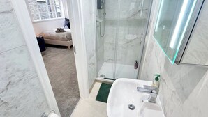 A bathroom with a shower, a sink, and a toilet.