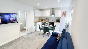 A compact living space with a kitchenette, a dining area, and a seating area with a sofa.