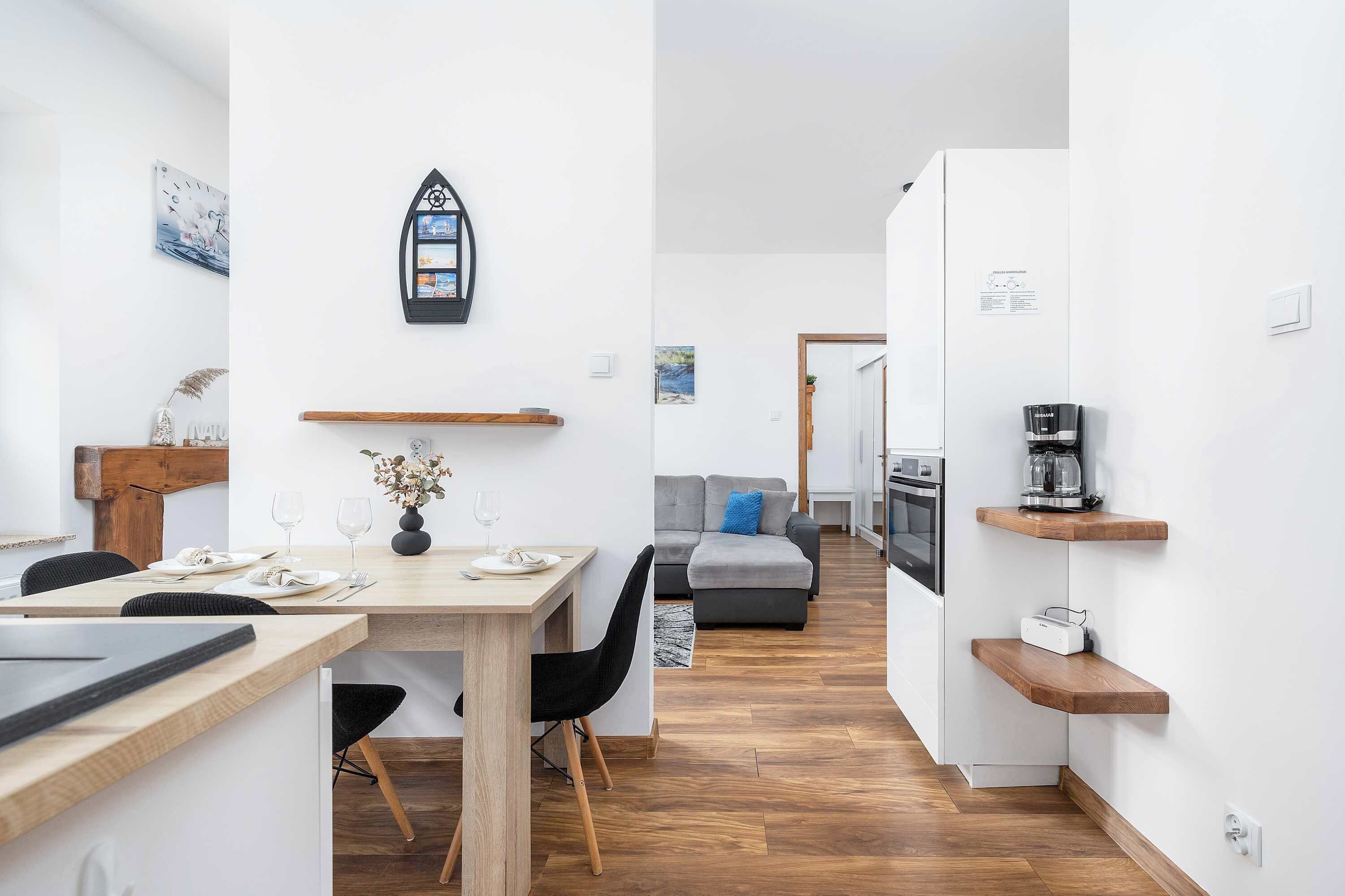 Eine moderne Küche mit Holzausziehtisch, einem eingebauten Backofen und einer Kaffeemaschine auf einem Regal.