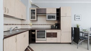 Eine moderne Küche mit Einbauofen, Mikrowelle und einem Essbereich mit Tisch und Stühlen.