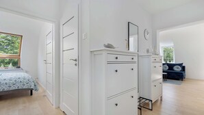 A bedroom with a bed, a dresser, a mirror, and a blue sofa.