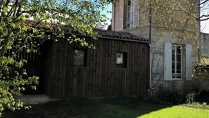 A rustic wooden building with a tiled roof, a small window, and a door.