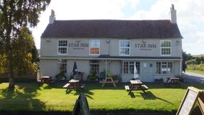 A two-story building with the name 'Star Inn' on the facade, featuring a traditional architectural style with a tiled roof and multiple windows. - the Star Inn (Weaverthorpe)