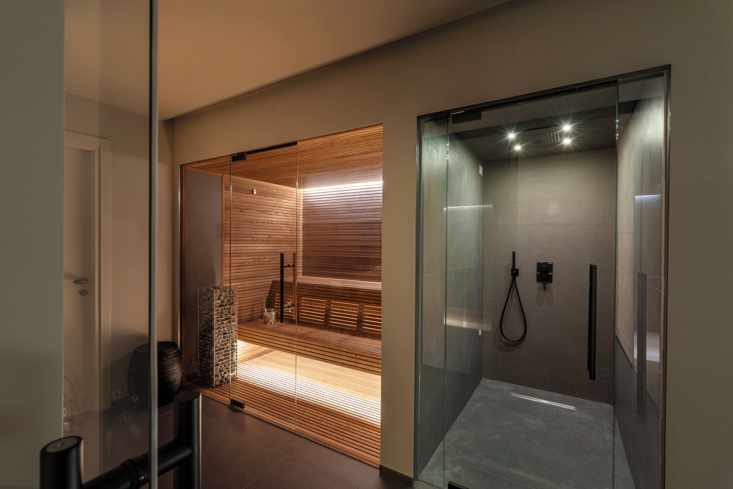 Een moderne badkamer met een douchecabine van glas, houten lambrisering en een zichtbare handdoekhouder.
