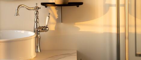 A bathroom with a round mirror, a white sink, and a modern faucet.