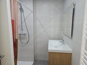 Een douche, een haardroger, handdoeken, toiletpapier