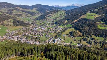 A town nestled in a valley surrounded by forested hills and mountains.