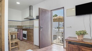 Eine Küche mit Herd, Backofen und einem an der Wand befestigten Fernseher.