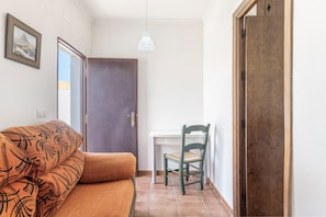 Une pièce comprenant un canapé, un fauteuil, un bureau et une porte.