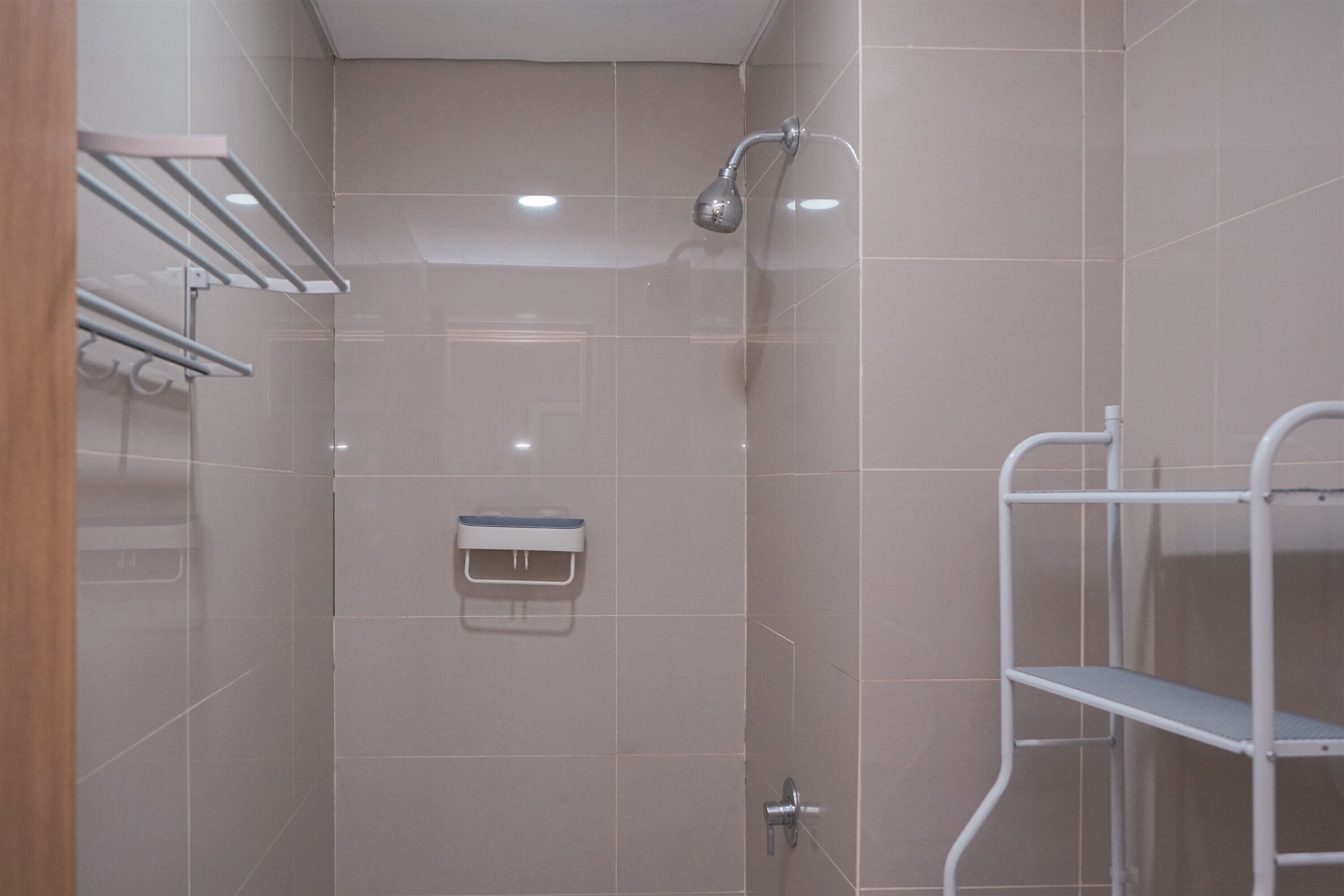Un baño moderno con ducha, toallero y estante.