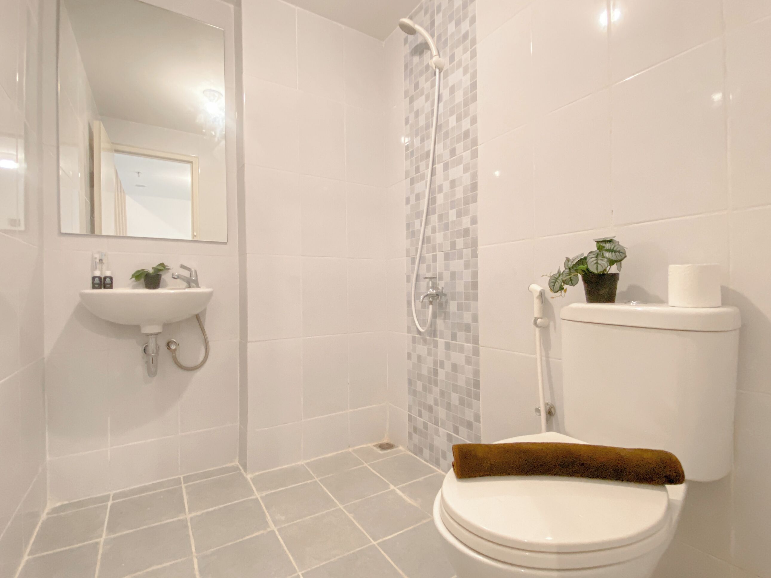 A modern bathroom with a toilet, sink, and shower.