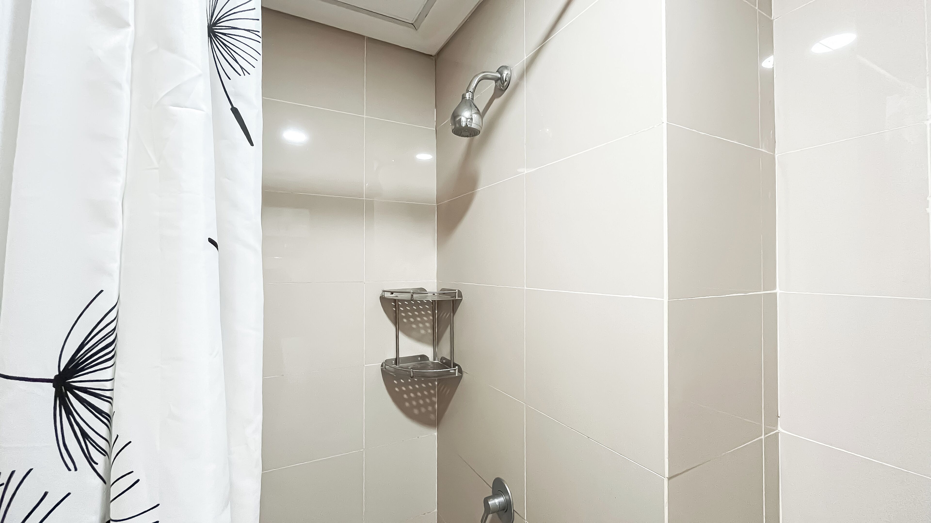 Un bagno con doccia, un porta asciugamani e un portasapone da doccia.