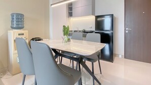 Una cocina moderna con una mesa de comedor, sillas, dispensador de agua y refrigerador.