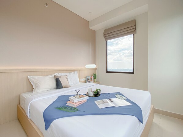 A modern hotel room with a large bed, a window with a view, and a bedside table with a lamp. - Modern Look And Cozy 2Br Apartment Transpark Cibubur (Depok)