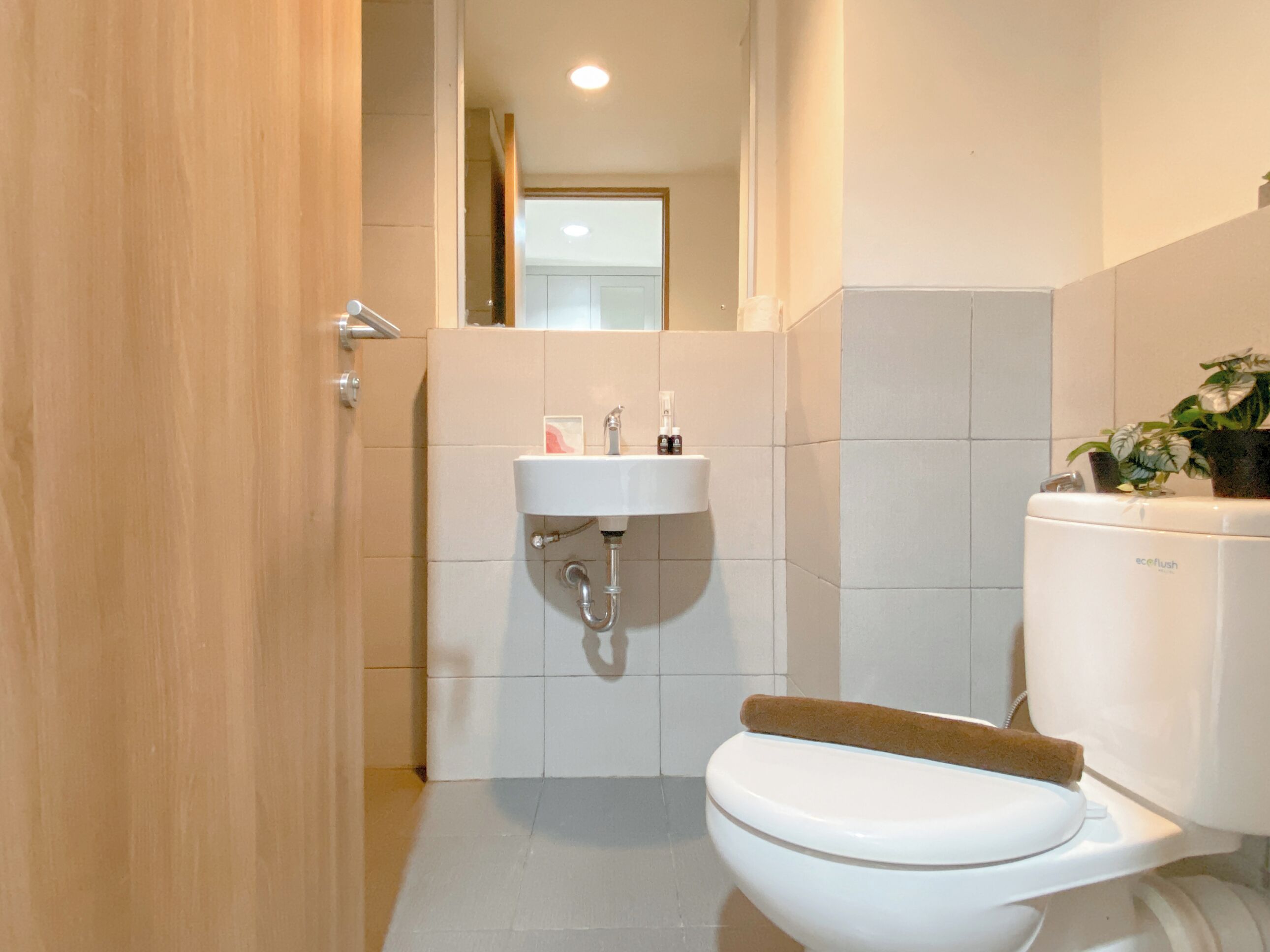 Un bagno con il water, un lavandino e uno specchio.