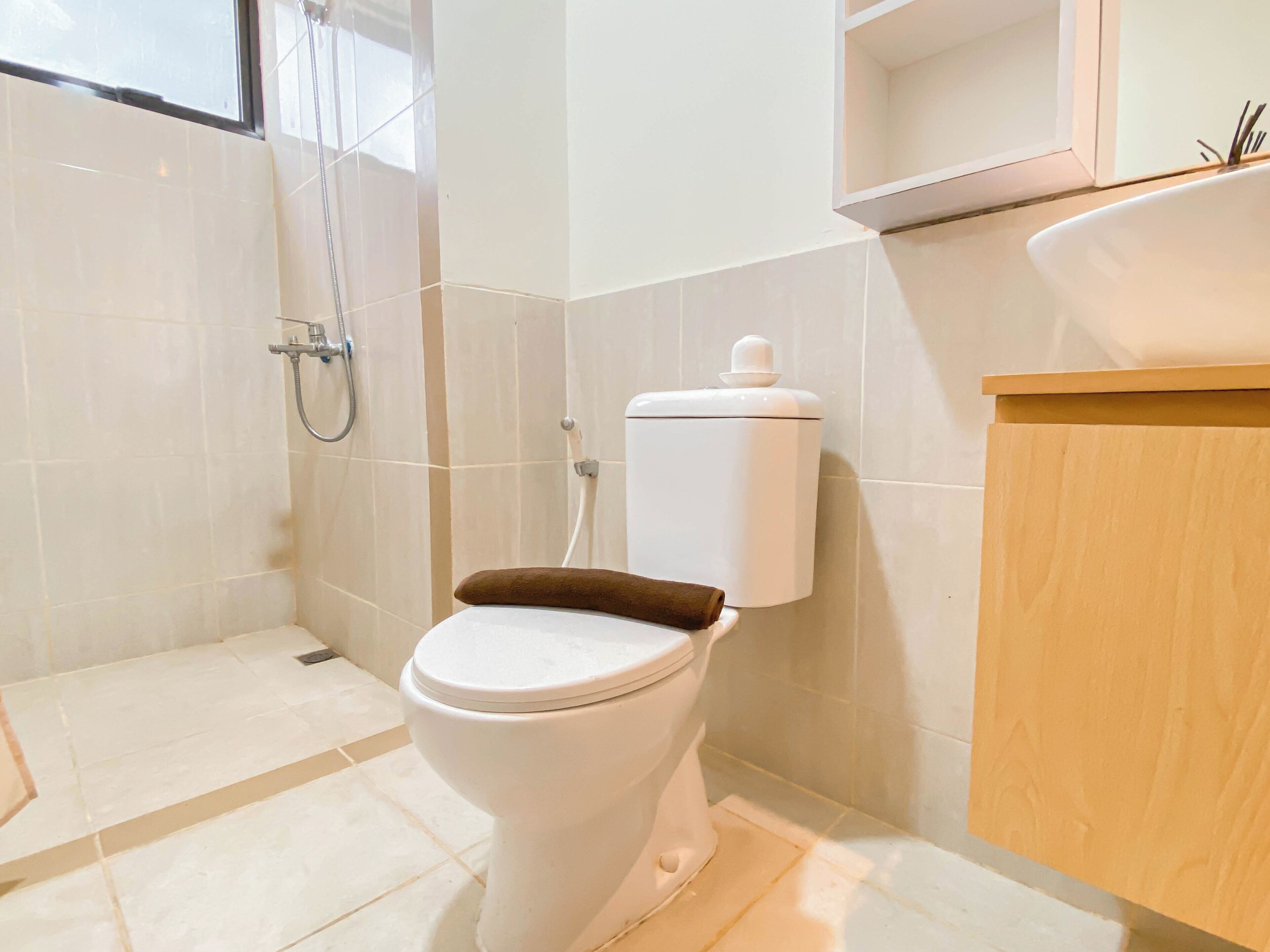 Een moderne badkamer met toilet, douche en wastafel.