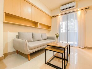 Una sala de estar moderna con un sofá, una mesa de centro y un aire acondicionado de pared.