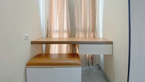 Una habitación pequeña y cerrada con un escritorio de madera y un banco.