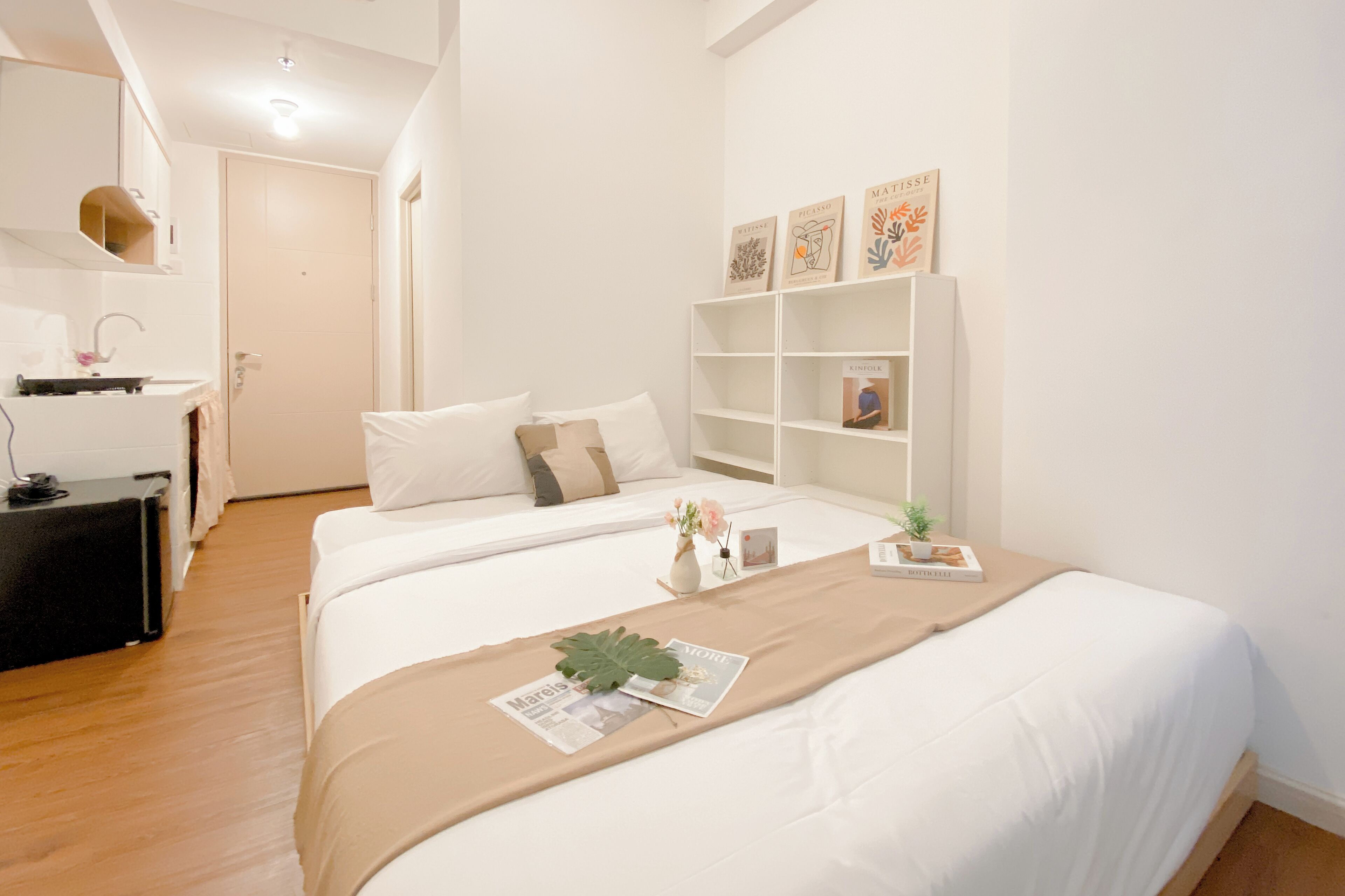 Una camera da letto moderna con un letto grande, comodini, una libreria e una piccola scrivania con una lampada.