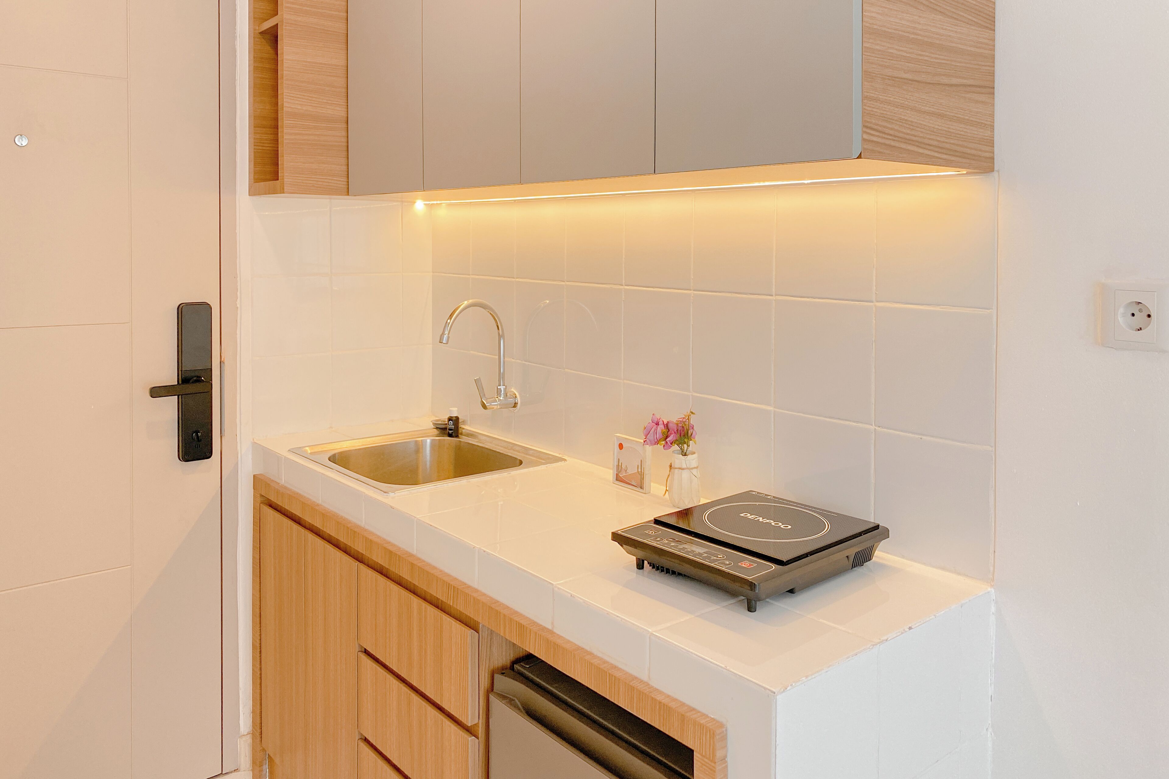 Eine moderne Küche mit Spüle, einem eingebauten Backofen und Holzschränken.