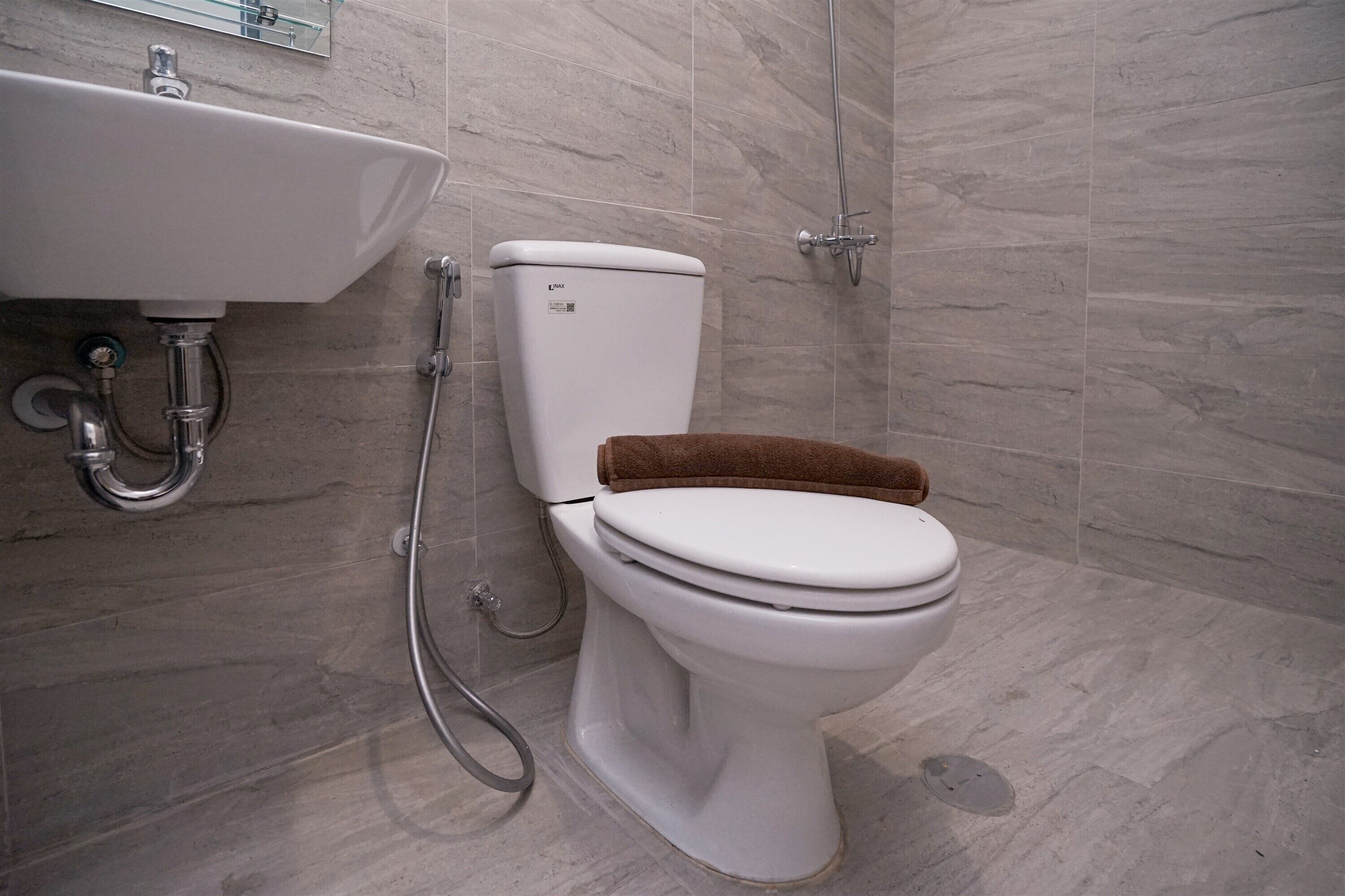 A bathroom with a white sink, toilet, and shower.