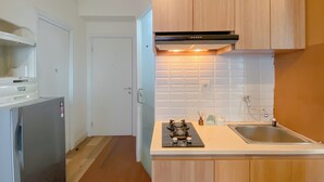 Una cocina compacta equipada con estufa a gas, horno empotrado, microondas y pileta.