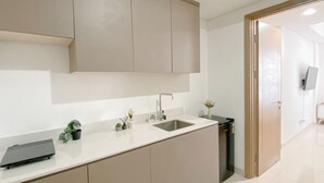 Una cocina moderna con un lavamanos, armarios y una pequeña planta en la encimera.