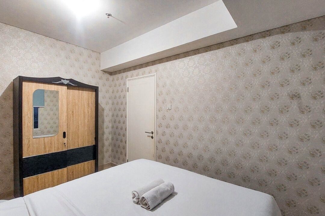 A bedroom with a bed, a wardrobe, a door, and a skylight.