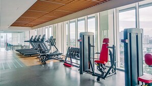 A modern gym with treadmills, dumbbells, and weight machines. - Spacious Studio At Apartment The Smith Alam Sutera (Tangerang)
