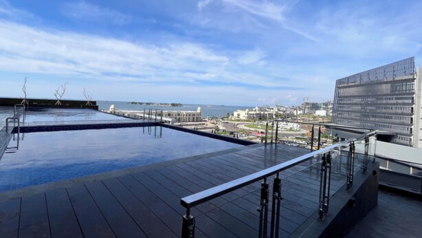 Ein Pool auf dem Dach mit freiem Blick auf die Stadt und das Meer.