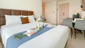 Ein Hotelzimmer mit einem großen Bett, einem Schreibtisch und einer Küchenzeile.